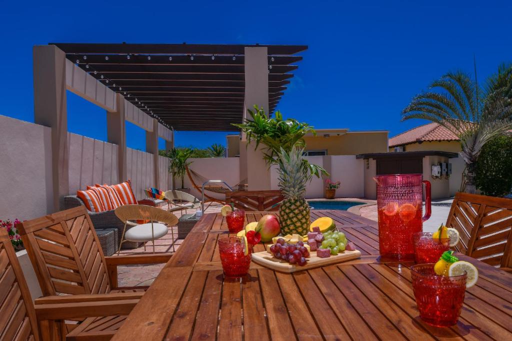 a wooden table with a tray of fruit on a patio at Villa Tamar in Palm-Eagle Beach