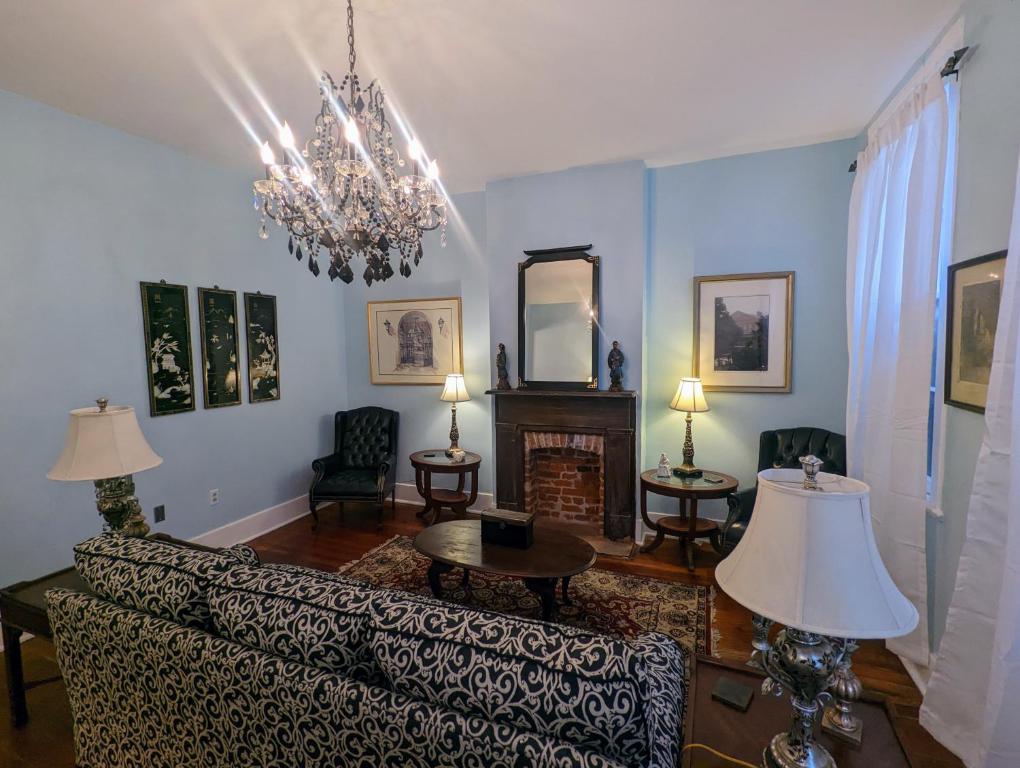 a living room with a couch and a chandelier at Villas de Frenchmen in New Orleans