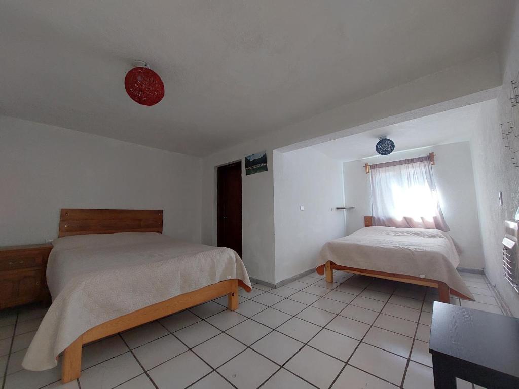 a bedroom with two beds and a window at Casa Nopal Tu casa vacacional tipo hotel in Creel