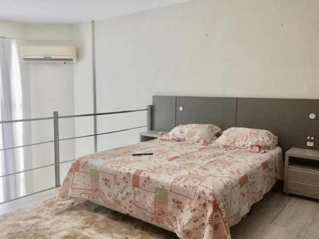 - une chambre avec un grand lit et une couverture rose dans l'établissement Saint Sebastian Flat 615 - Com Hidro! até 4 pessoas, Duplex, no centro, à Jaraguá do Sul