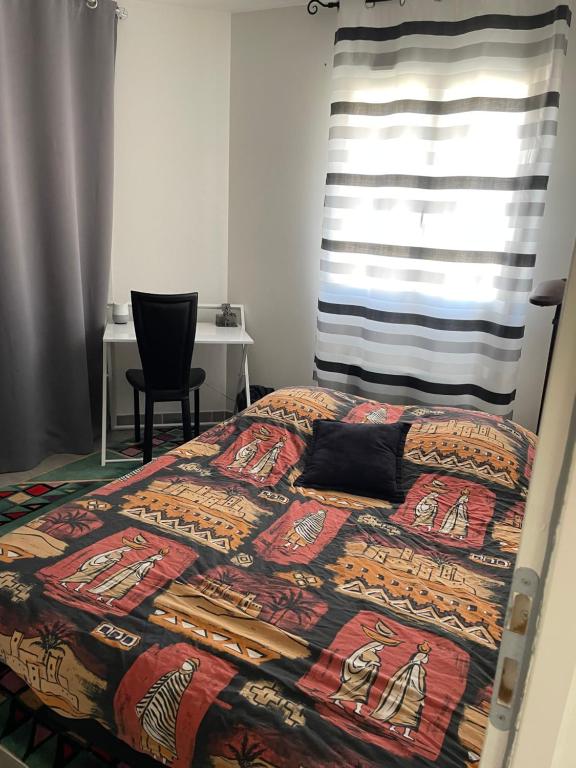 - un lit avec une couette colorée dans une chambre dans l'établissement Chambre privée au cœur du Verdon, à Saint-Julien