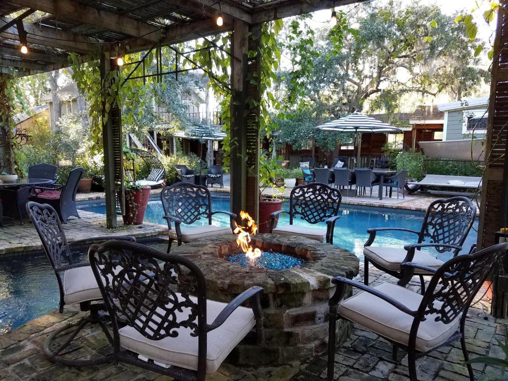 een patio met stoelen en een vuurplaats naast een zwembad bij Cedar Oaks Inn The Bath House in Dickinson