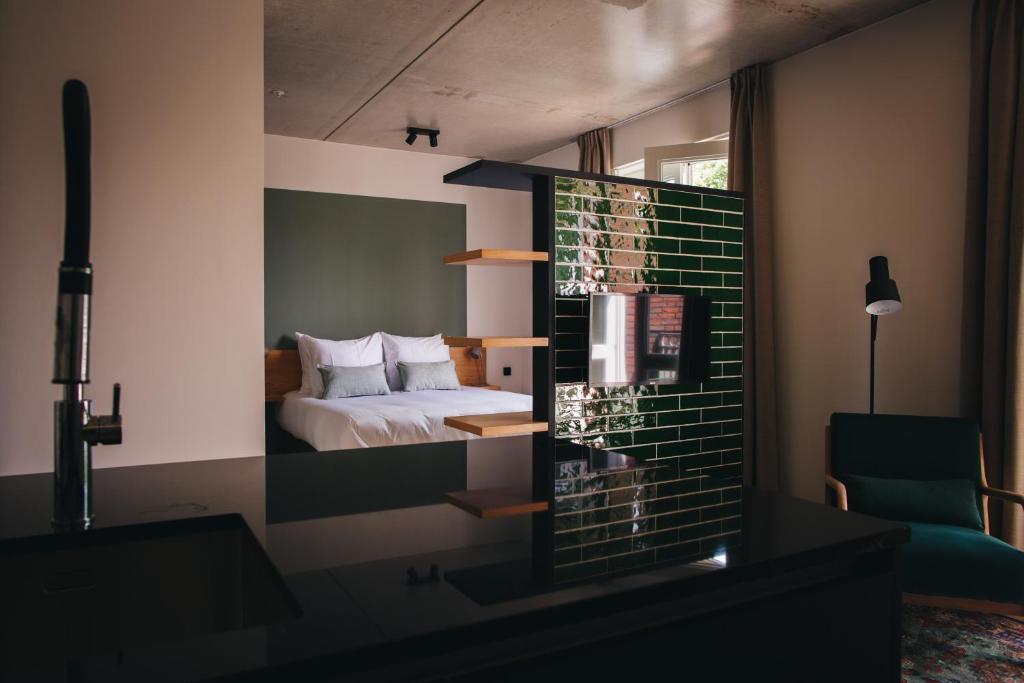 a bedroom with a bed and a mirror at Dudok Studio's Arnhem-Oosterbeek in Oosterbeek