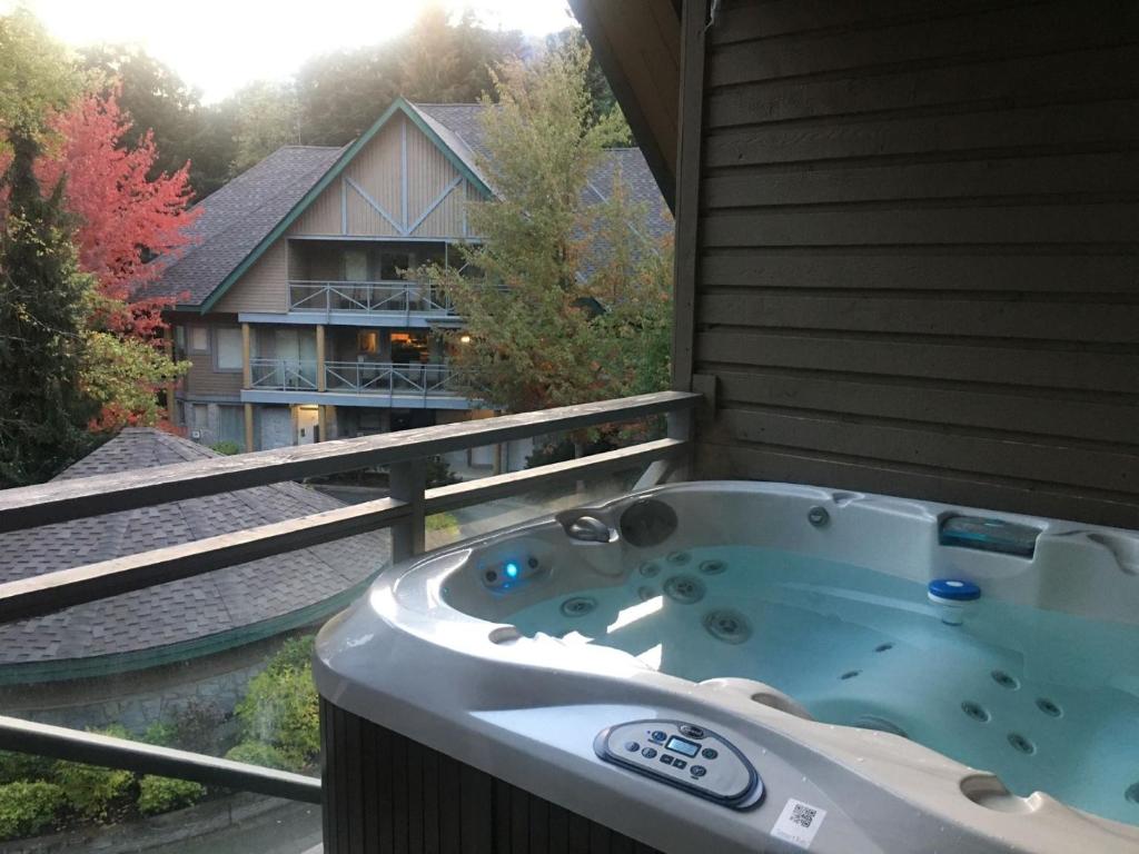 eine Whirlpool-Badewanne auf dem Balkon eines Hauses in der Unterkunft Valhalla Vacations at Whistler in Whistler