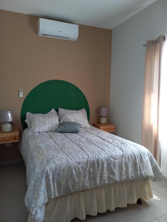 sypialnia z dużym łóżkiem z zielonym zagłówkiem w obiekcie Hotel y Plaza JMI w mieście Siguatepeque