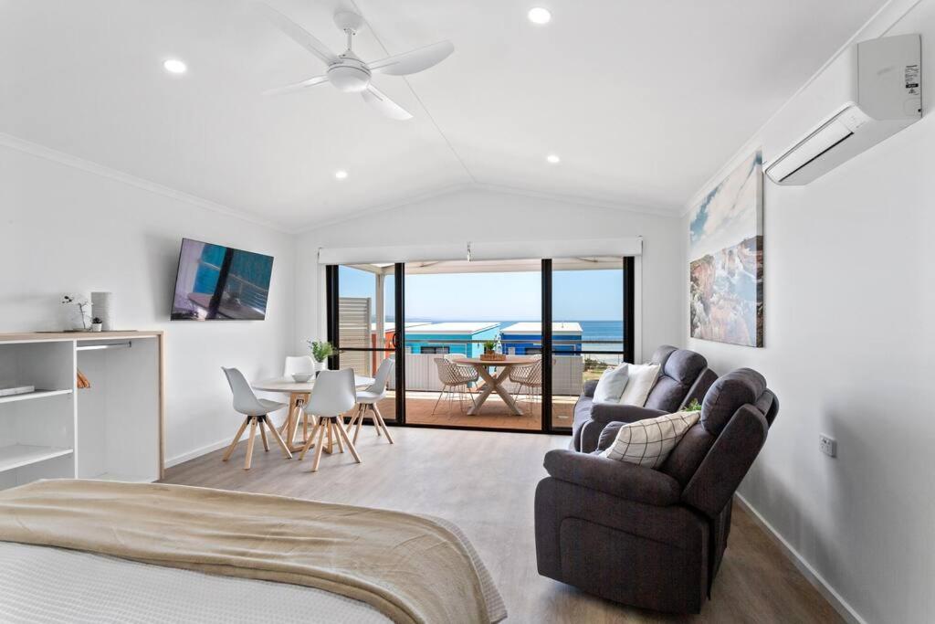 a living room with a bed and chairs and a table at Port Lincoln Beachfront Apartment 7 in Port Lincoln