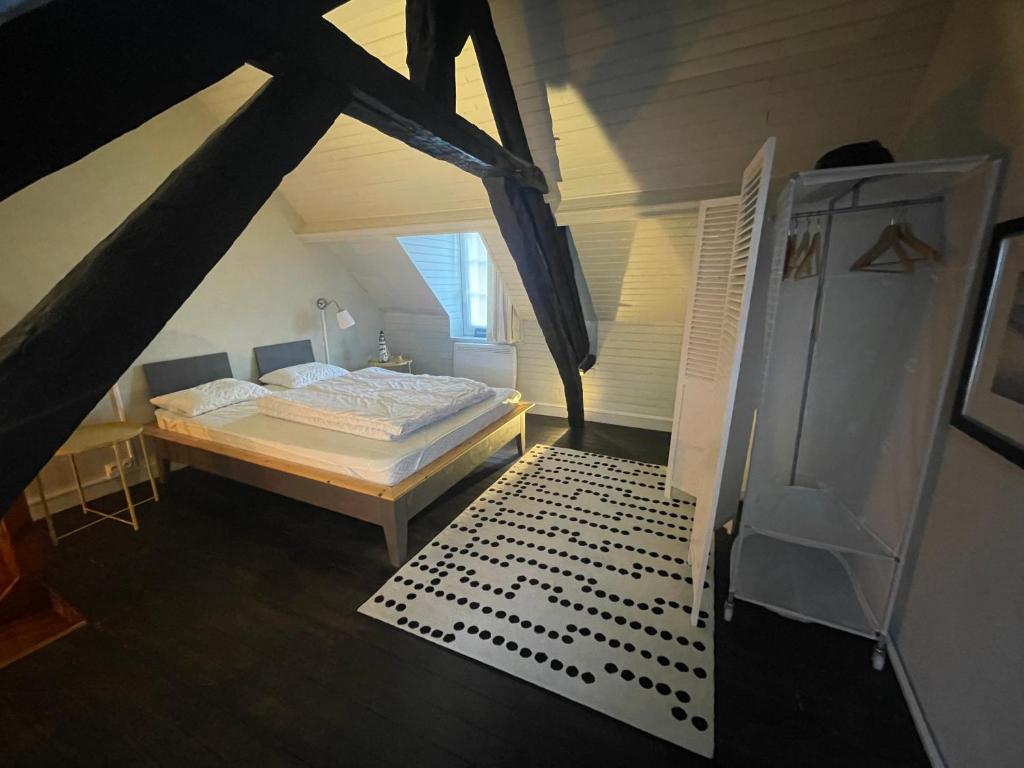a attic bedroom with a bed and a staircase at GÎTE LES VOLETS BLEUS in Yport