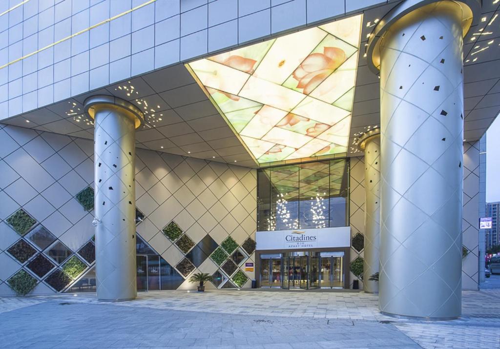 a building with a glass ceiling in a city at Citadines Intime City Hangzhou in Hangzhou