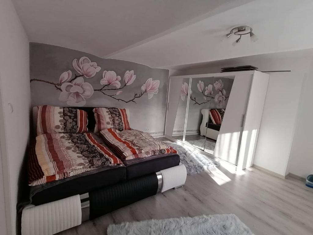 ein Schlafzimmer mit einem Bett mit einem Blumenbild an der Wand in der Unterkunft Ubytování Dobešov in Černovice