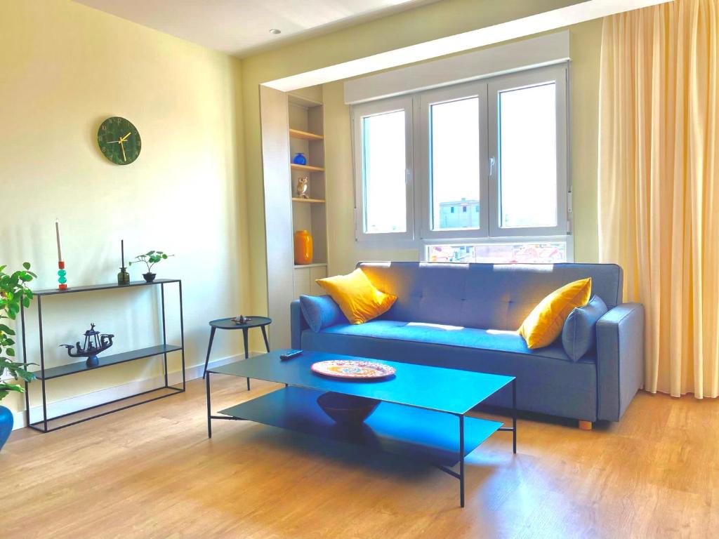 un soggiorno con divano blu e tavolo di SUITE PLAYA GIJON CENTRO, apartamento nuevo, 5 huéspedes VUT-3622-AS a Gijón