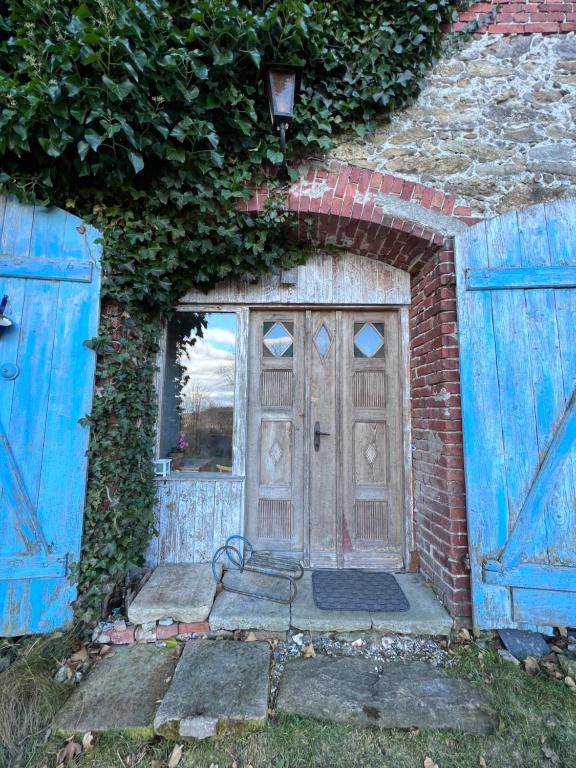 - une entrée pour un bâtiment en briques avec une porte en bois dans l'établissement Flat 56, à Stara Kamienica