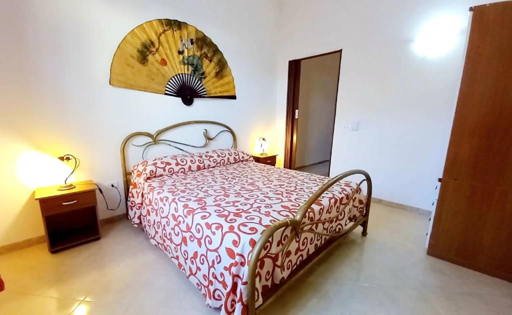 a bedroom with a bed with a red and white bedspread at Baffos House in Marsala
