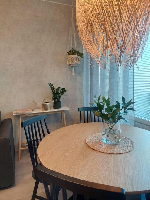 a dining room table with a vase with a plant on it at Ihastuttava kaksio Pieksämäen keskustasta in Pieksamaki