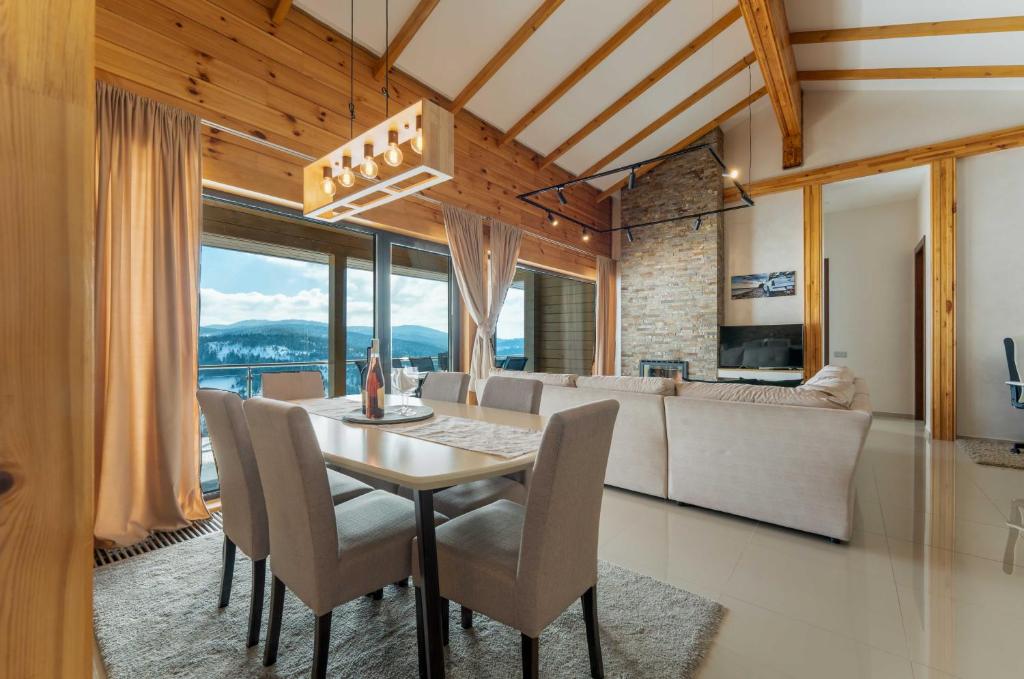 a dining room with a table and chairs and a couch at Vila Cigota Zlatibor in Zlatibor