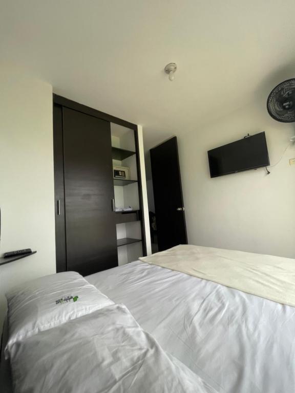 蒙特內格羅的住宿－Edificio guaduales del cafe 505A，一间卧室设有两张床,墙上配有电视。