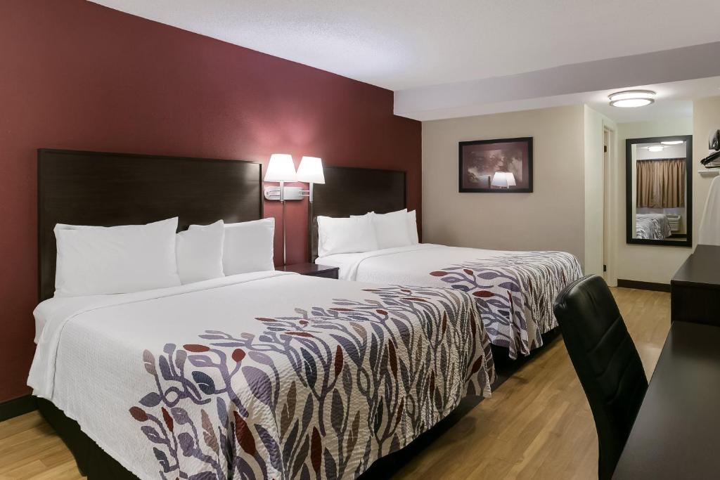 a hotel room with two beds and a table at Red Roof Inn Hershey in Hershey