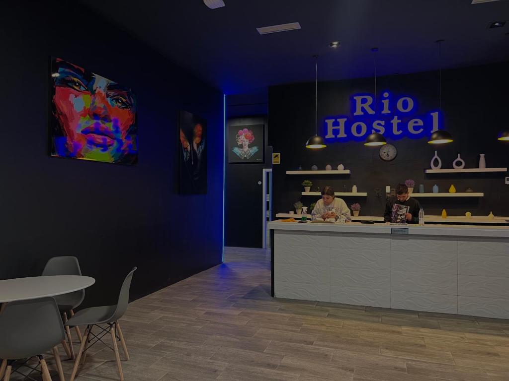 een restaurant met twee mensen aan een balie bij Rio Hostel in Madrid