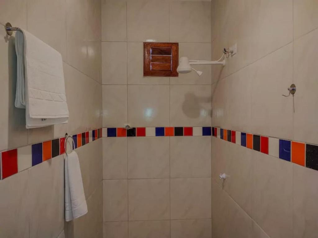 a bathroom with a shower with colorful tiles at Freddyssimo Preá in Prea