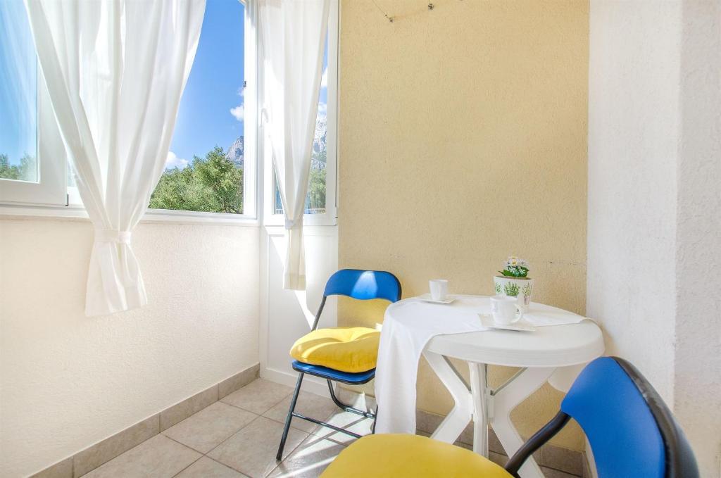 a small table and chairs in a room with a window at Apartment Studenka in Makarska
