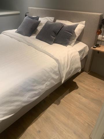 een groot wit bed met kussens erop bij B en B Volendam in Volendam