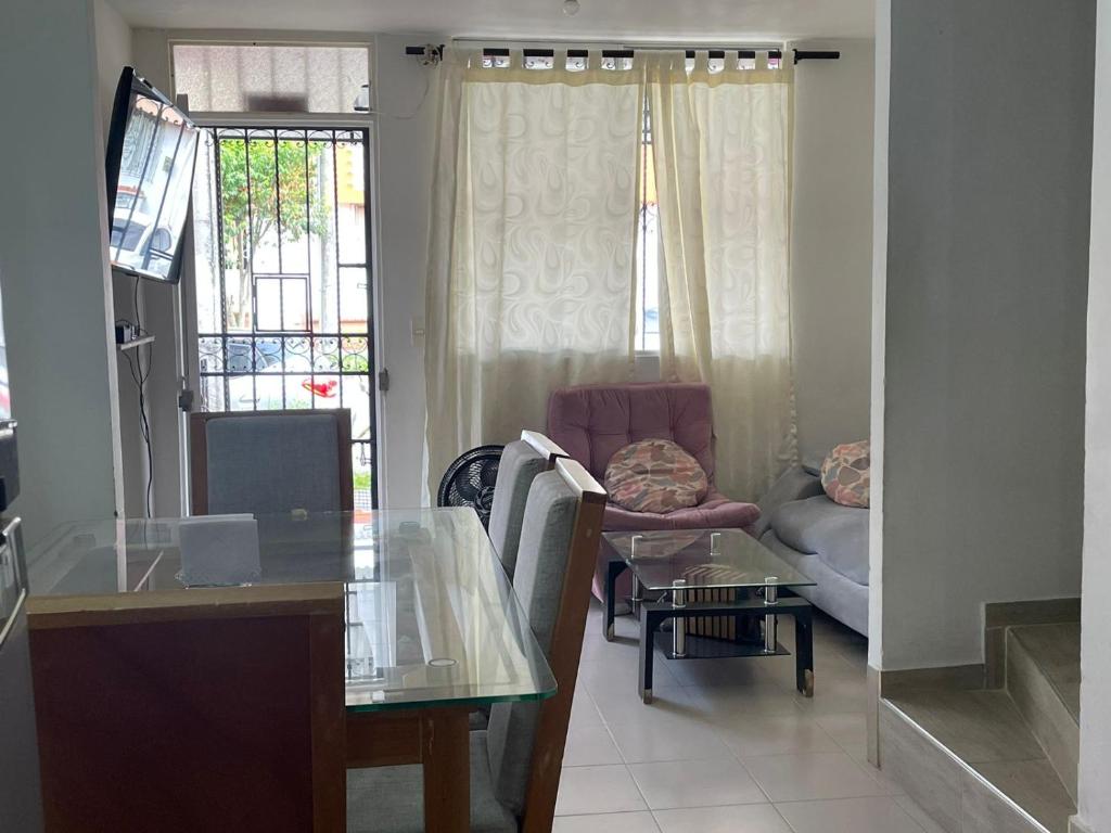 Casa Familiar Pereira Manzana في بيريرا: غرفة معيشة مع طاولة زجاجية وأريكة