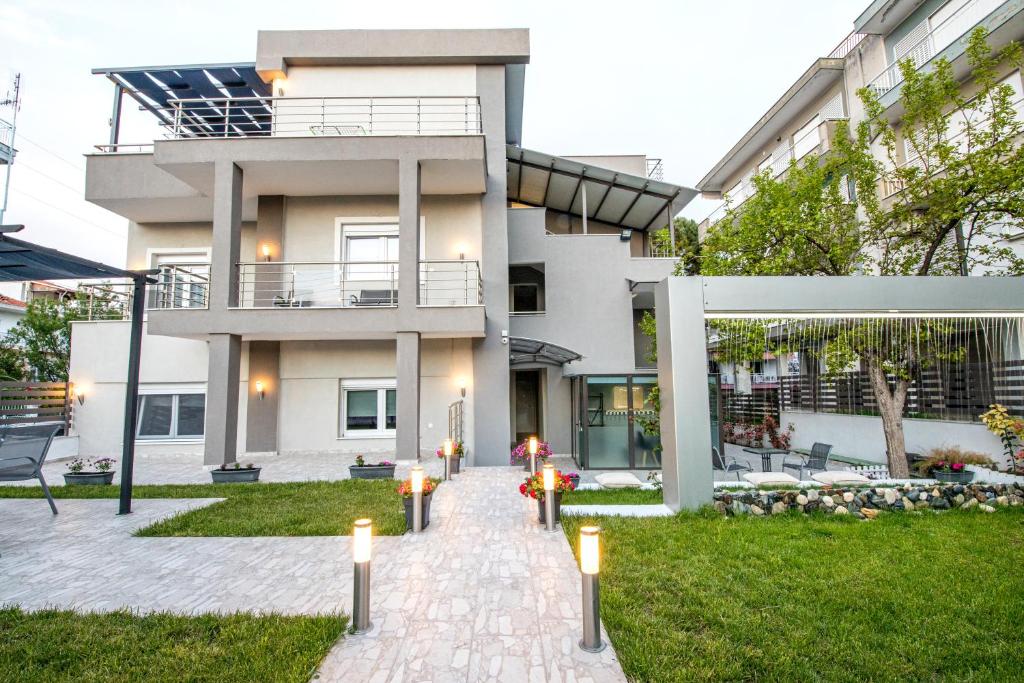 una casa con una pasarela delante de ella en StayInn Luxury Apartments en Nea Kalikratia
