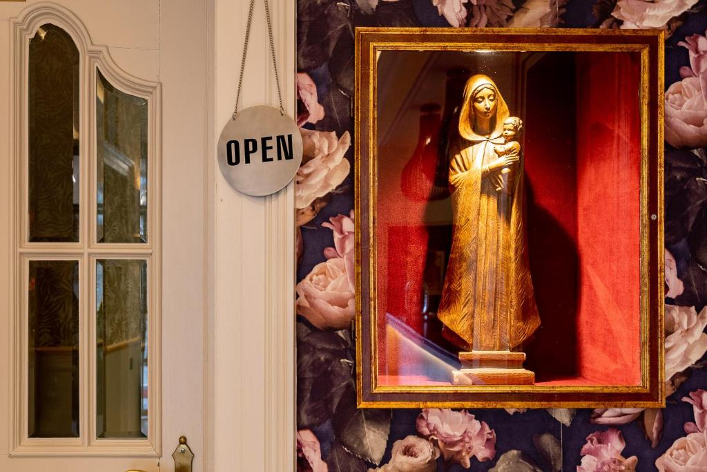 a statue of a christ redeemer in a mirror on a wall at Hotel Jacobs in Bruges