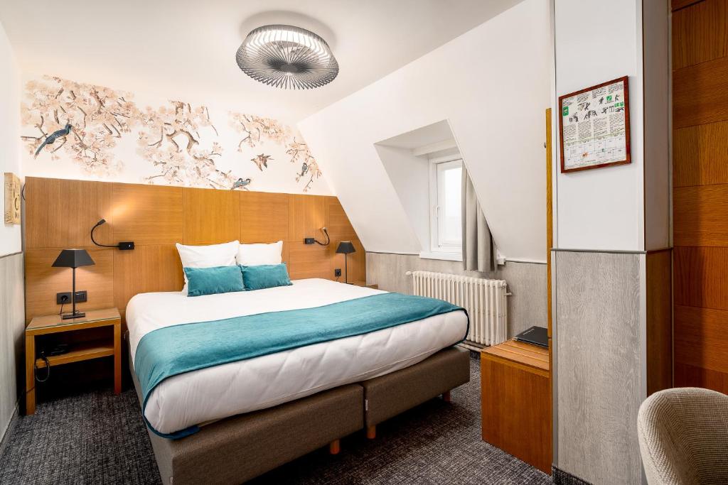 a hotel room with a bed with blue pillows at Hotel Jacobs in Bruges