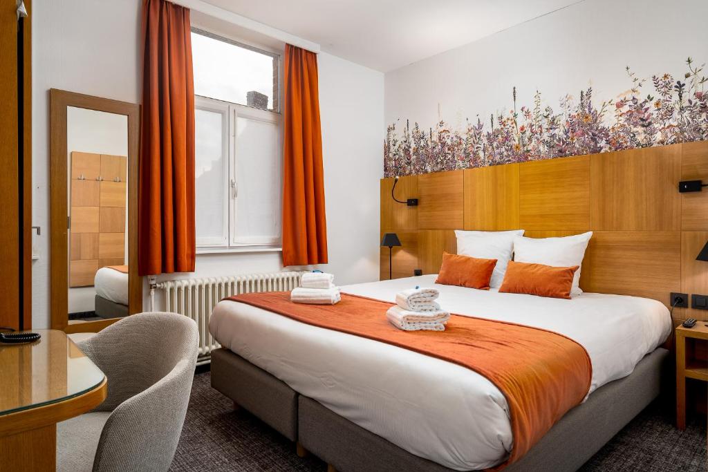 a hotel room with a large bed and a window at Hotel Jacobs in Bruges