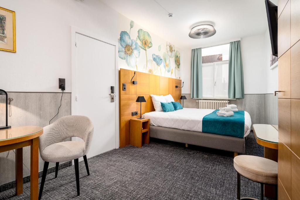 une chambre d'hôtel avec un lit, une table et des chaises dans l'établissement Hotel Jacobs, à Bruges