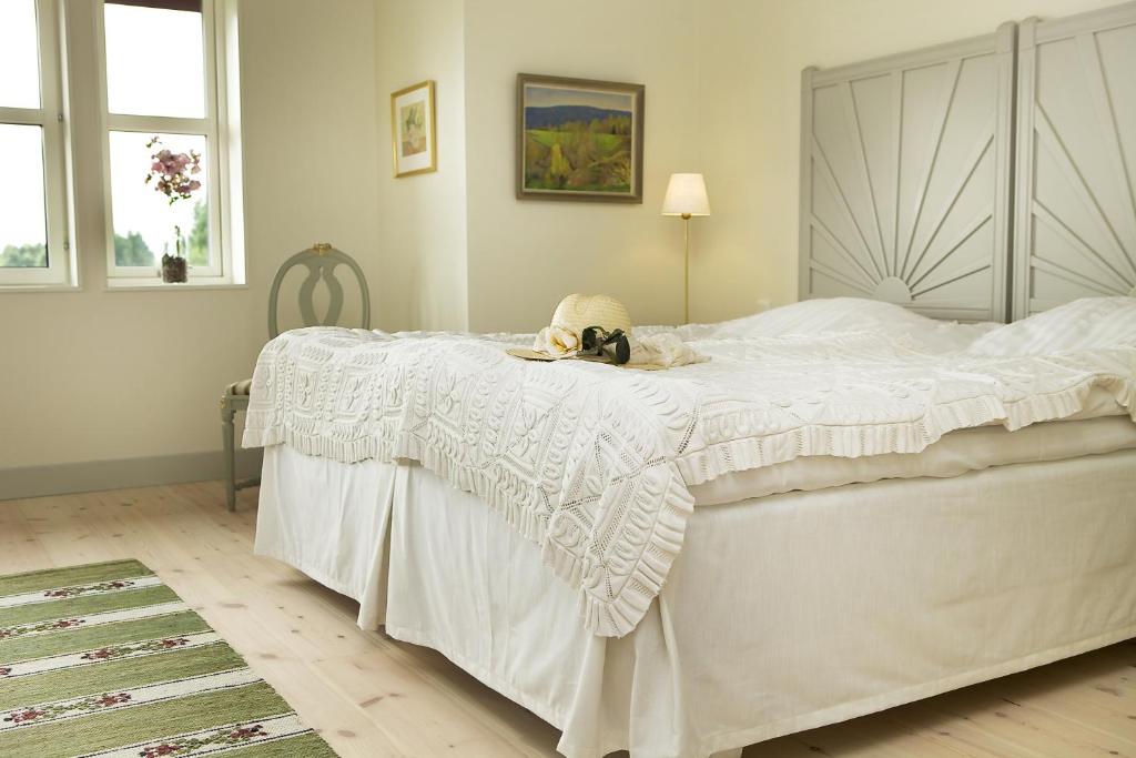 a bedroom with a white bed with a stuffed animal on it at Sahlströmsgården in Torsby