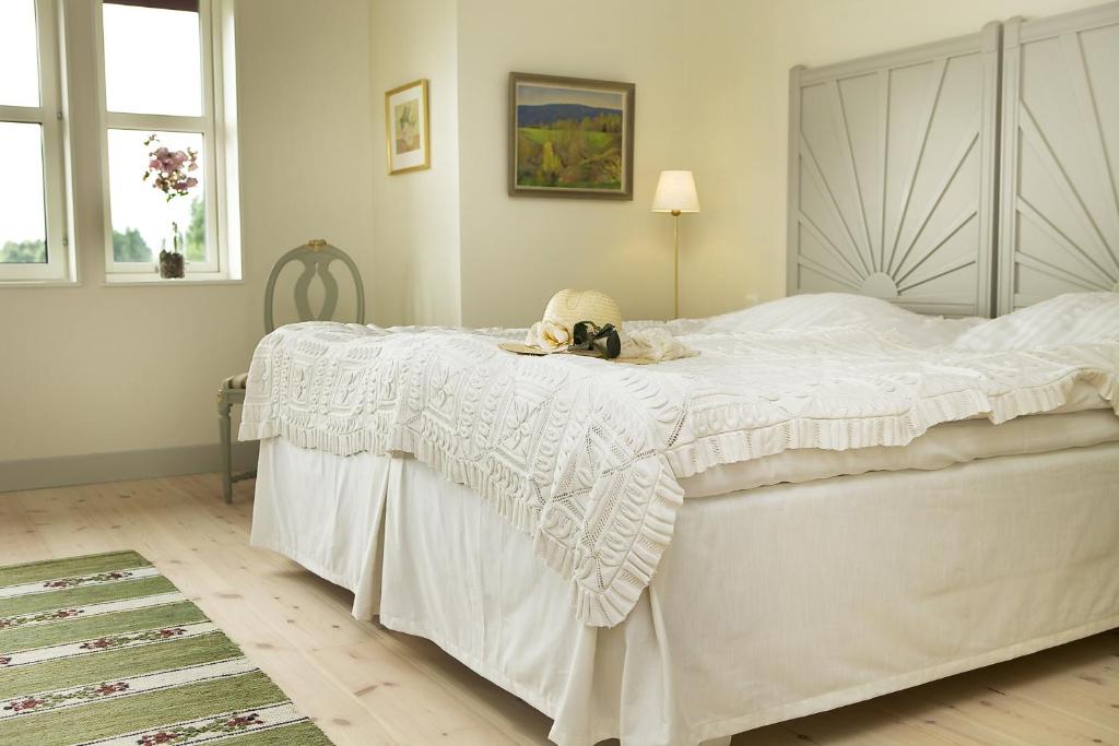 Un dormitorio con una cama blanca con un animal de peluche. en Sahlströmsgården, en Torsby