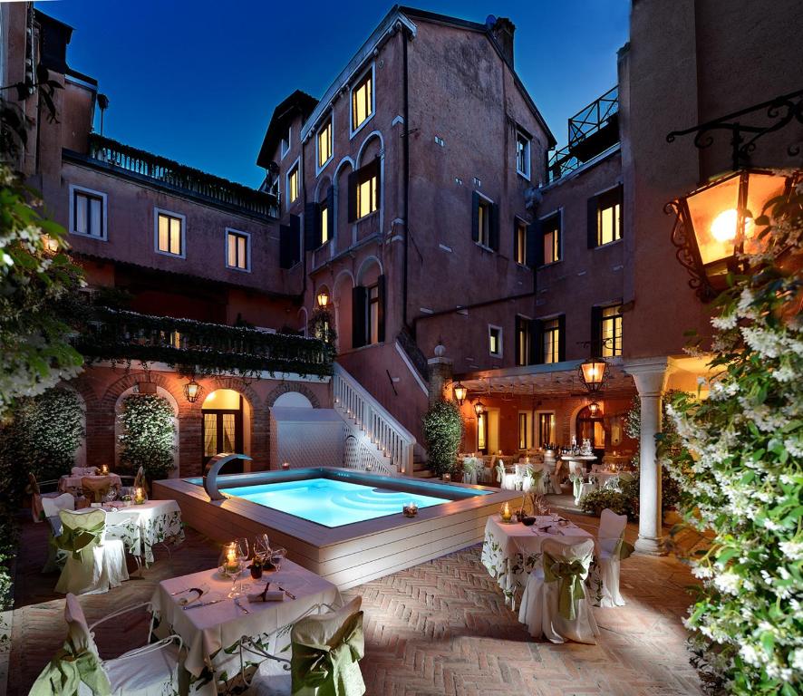 einen Innenhof mit einem Pool vor einem Gebäude in der Unterkunft Hotel Giorgione in Venedig