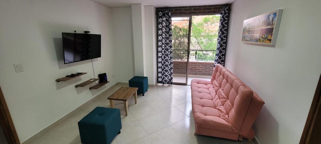 sala de estar con sofá rosa y mesa en MEDELLÍN SURAMERICANA APARTAMENTO 3, en Medellín