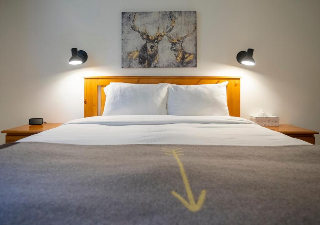 a bedroom with a large bed with white pillows at Hotel Mont-Tremblant in Mont-Tremblant