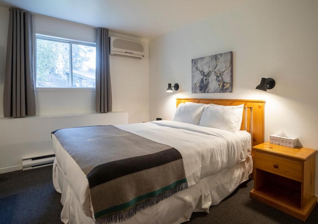 a hotel room with a large bed and a window at Hotel Mont-Tremblant in Mont-Tremblant