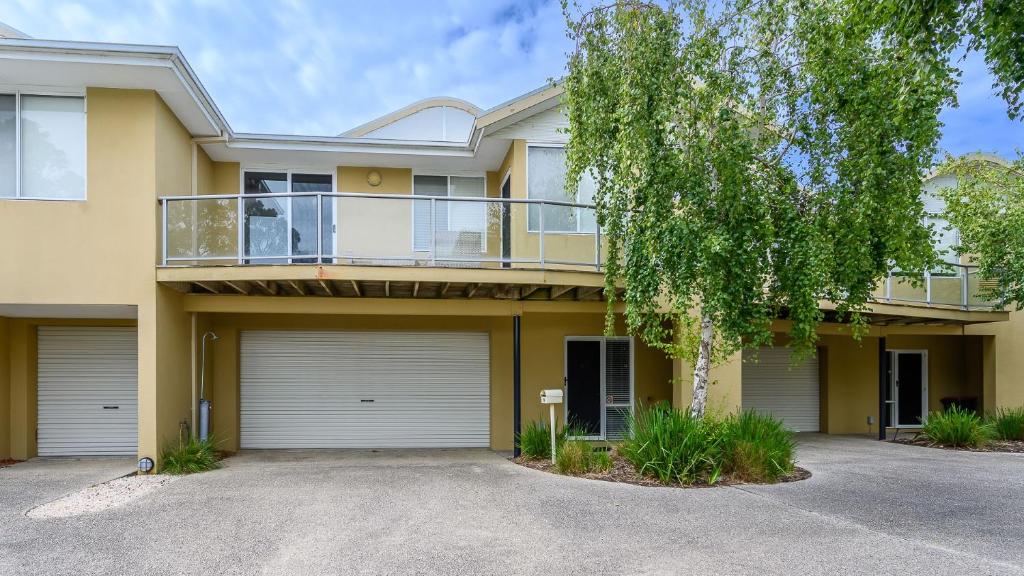 une maison avec un balcon et une allée. dans l'établissement Sandpiper 9 - Close to Town and Beach, à Inverloch