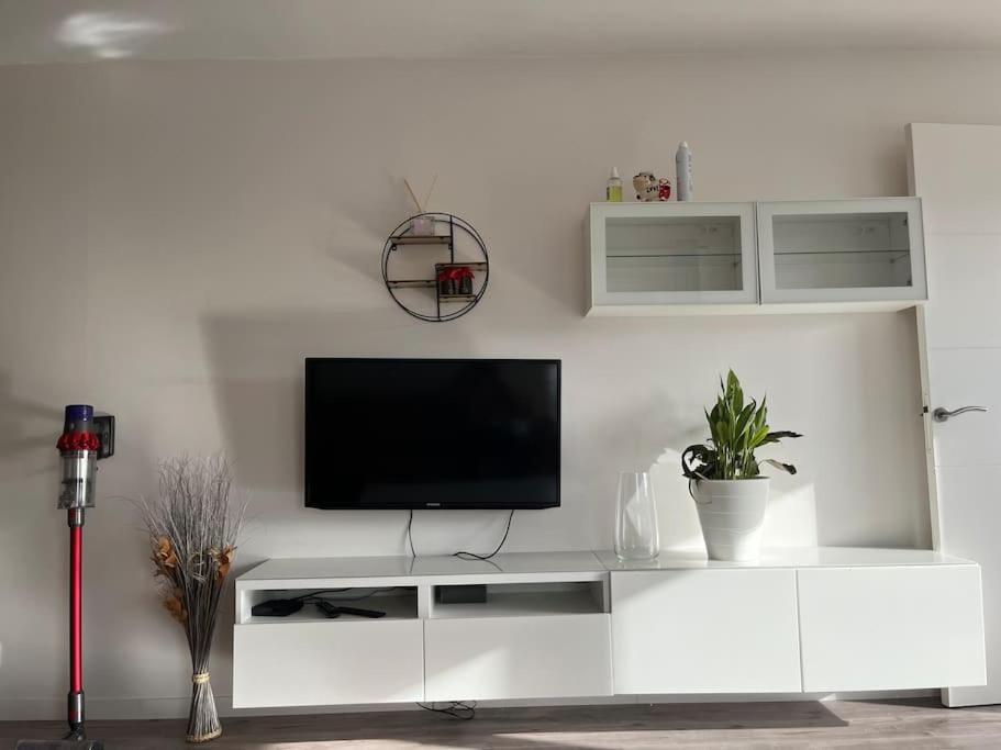 a white entertainment center with a television on a wall at Appartement de Romainville in Romainville