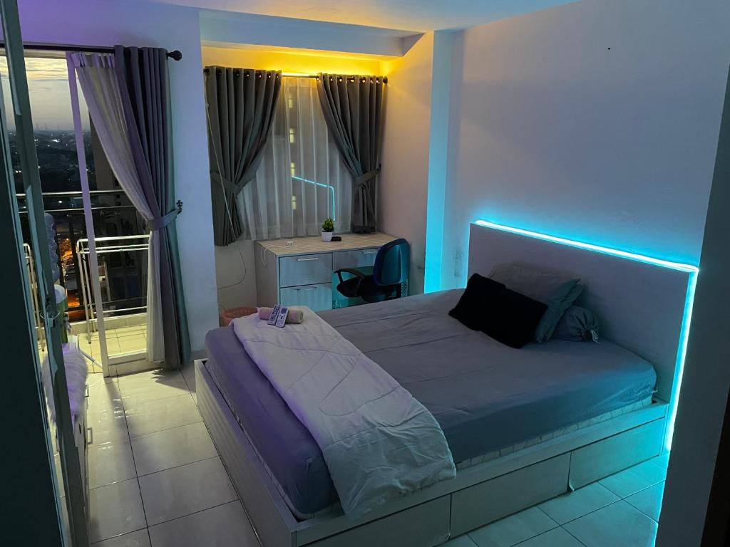 Schlafzimmer mit einem Bett mit blauem Licht in der Unterkunft Apartemen Margonda Residence 3 Depok in Kemirimuka Dua