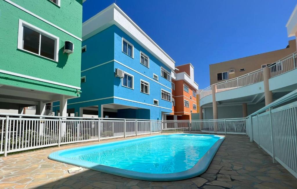 a swimming pool in the courtyard of a building at Condomínio San Victor in Bombinhas