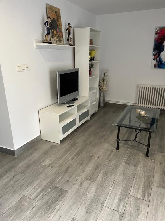 a living room with a television on a white cabinet at Paz Jardín-Madrigueras in Madrigueras