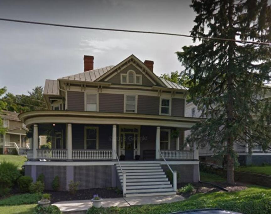 a large house with a porch and stairs in front at The Queen's Gambit ( A Luxury 2nd Floor Apt in Downtown Staunton) in Staunton