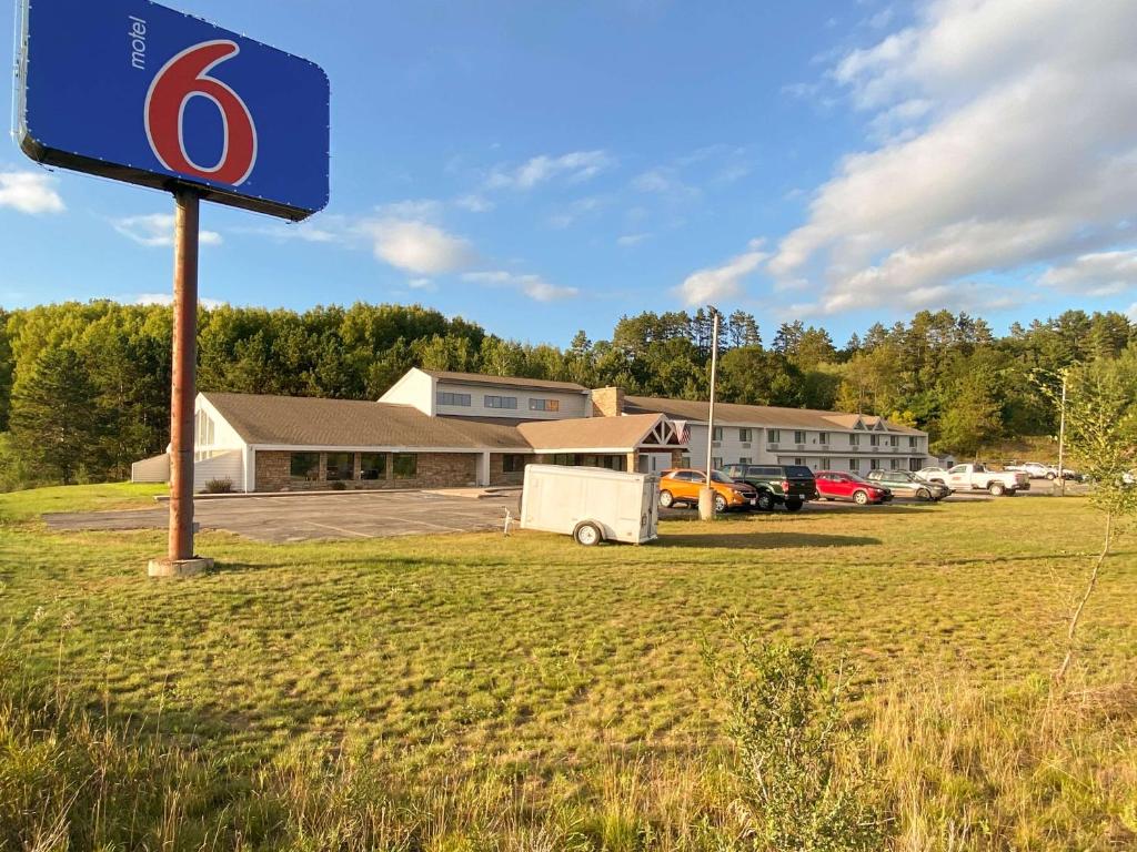 um sinal de número azul em frente a um edifício em Motel 6 Norway MI em Norway