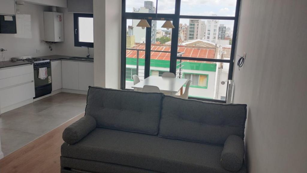 ein Wohnzimmer mit einem Sofa und einem großen Fenster in der Unterkunft Moderno 2 amb con Cochera in Mar del Plata