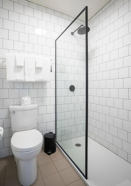 a bathroom with a toilet and a glass shower at Hotel Mont-Tremblant in Mont-Tremblant