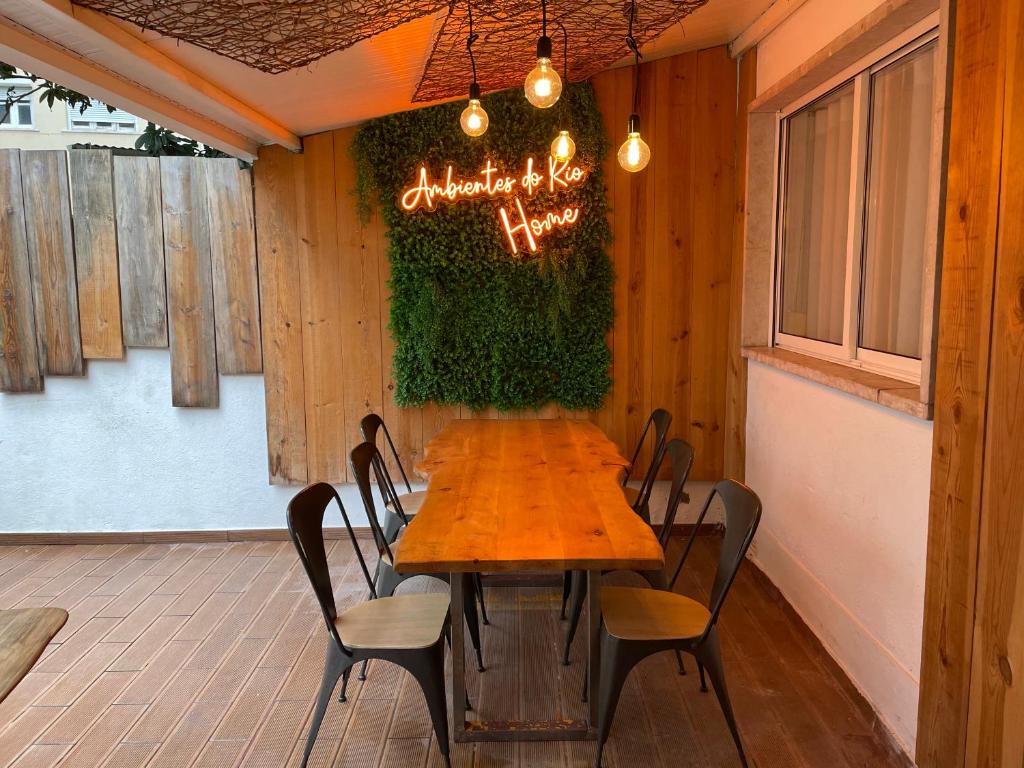 a wooden table and chairs in a room at Ambientes do Rio Home in Sacavém