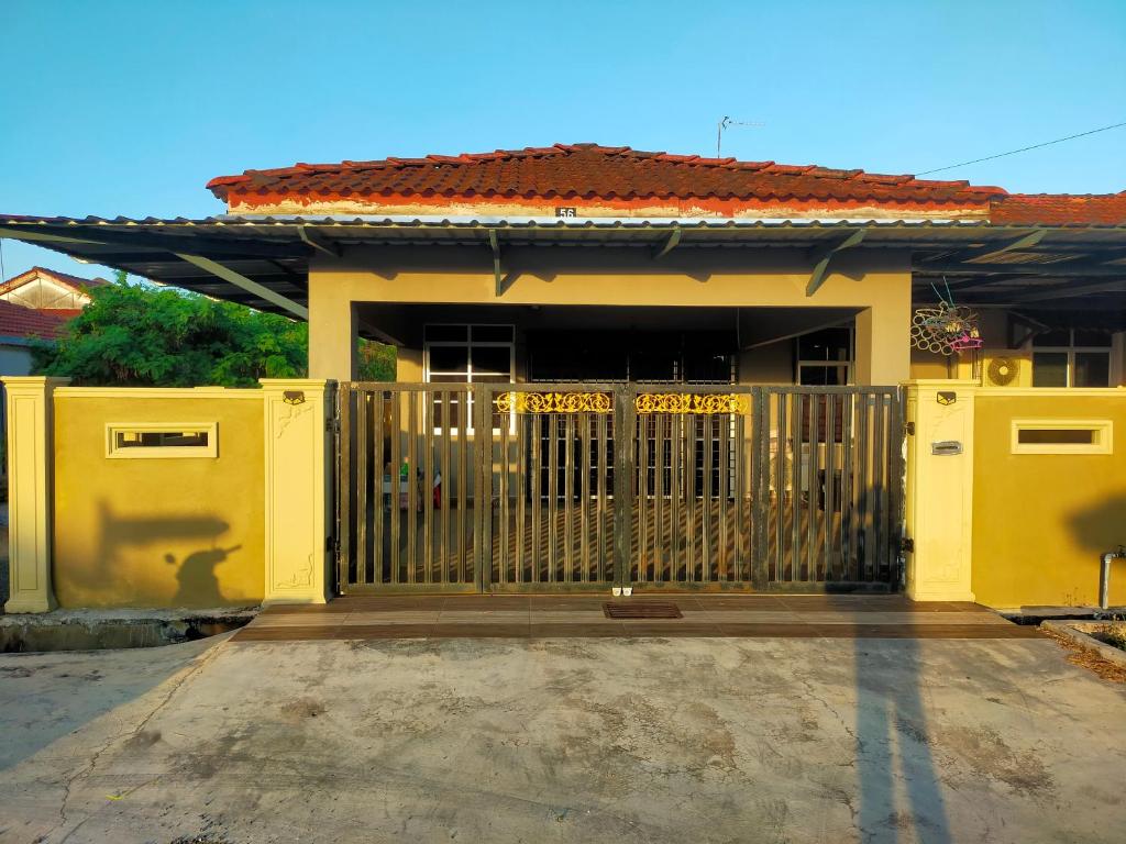 une maison jaune avec une porte devant elle dans l'établissement Alor Setar Homestay, à Kuala Kedah