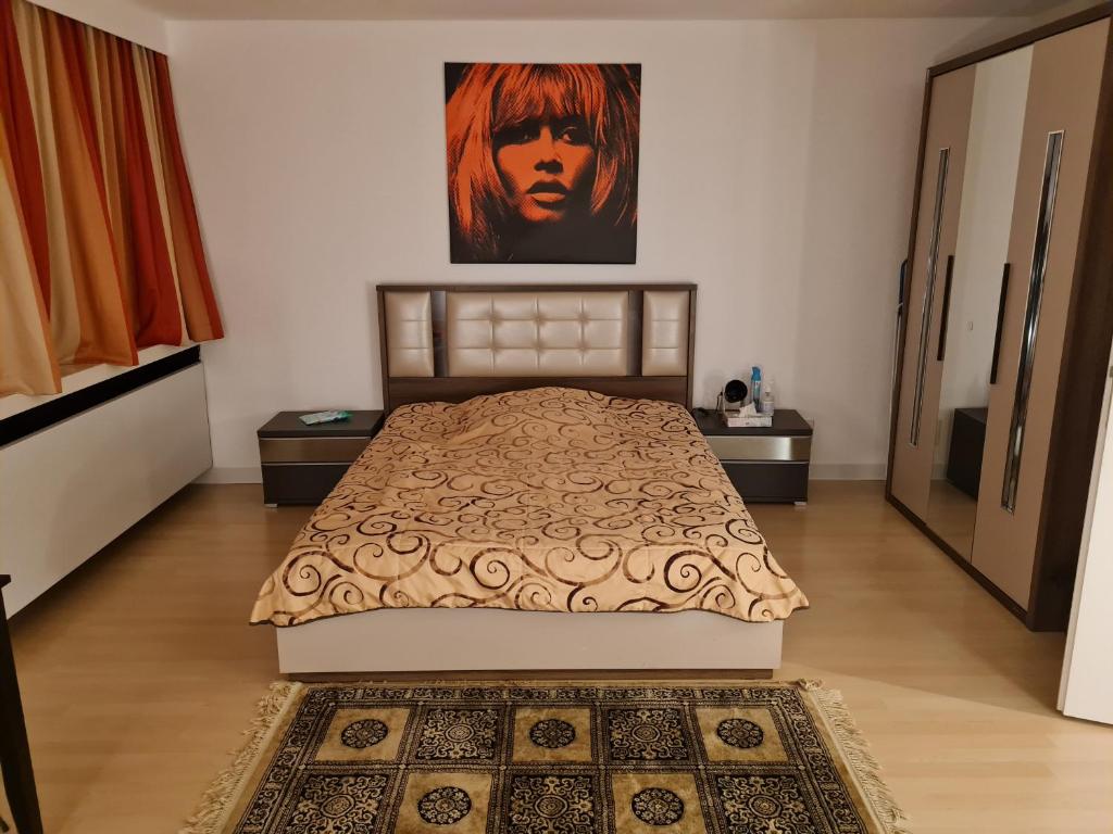 een slaapkamer met een bed en een schilderij aan de muur bij Einzimmer Apartments im Si-Centrum Stuttgart-Möhringen in Stuttgart