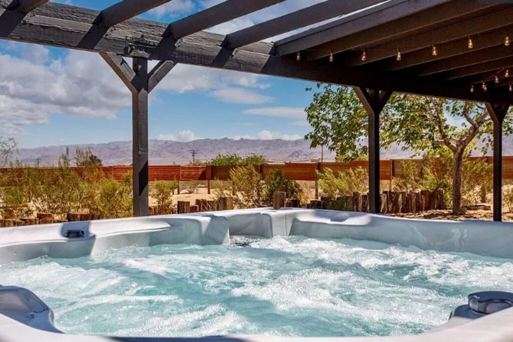 uma banheira de hidromassagem num quintal com vista em Cheerful 2bedroom home with hot tub and cowboy pool in Joshua Tree em Joshua Tree