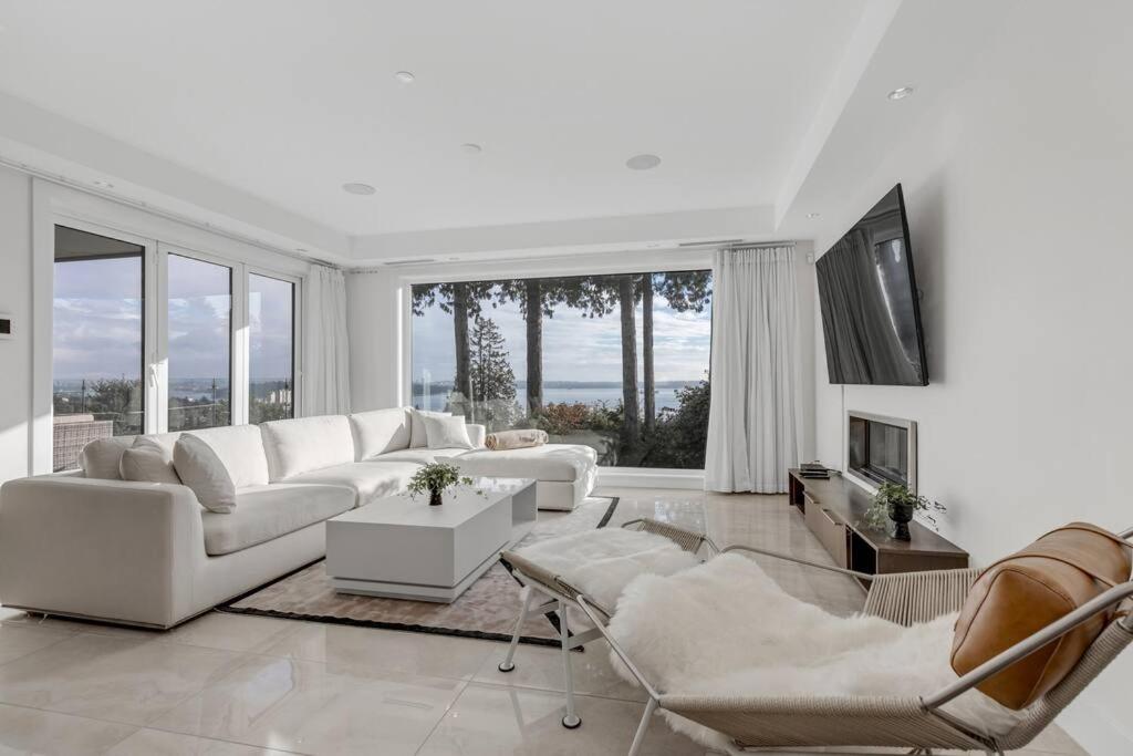 un soggiorno con mobili bianchi e ampie finestre di Modern Home with Breathtaking Ocean & City Views a West Vancouver